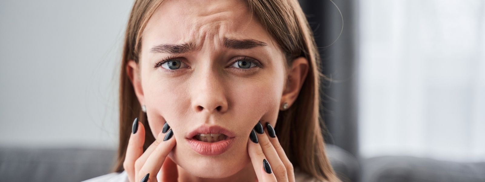 Girl in pain holding her face