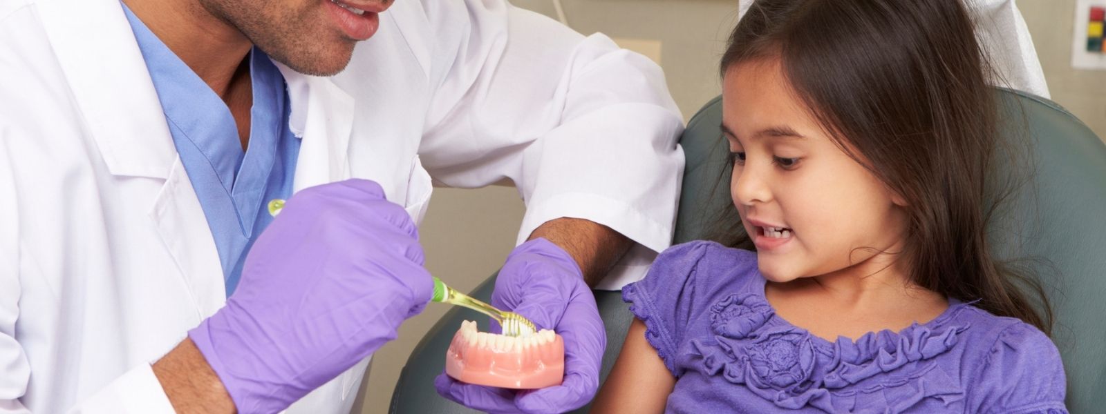Dentist teaching a kid to brush