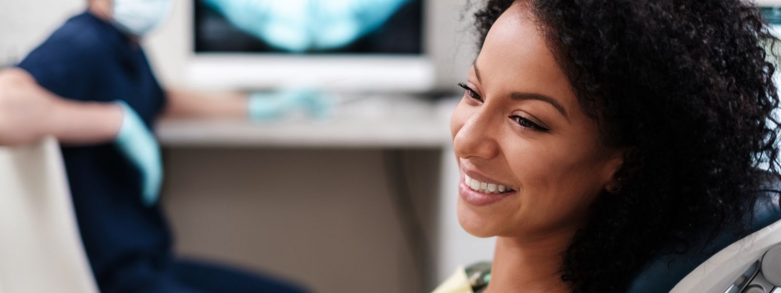 Girl with black curl hair at dental chair