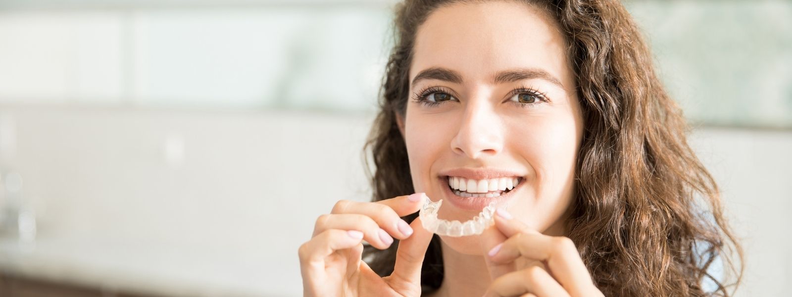 Happy woman holding a Invisalign