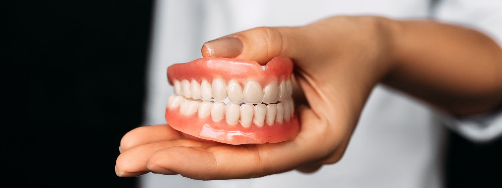 A dentist holding a Dentures